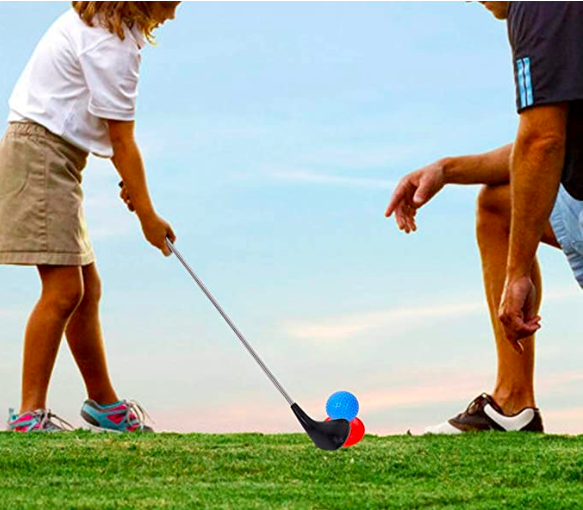 Father teaching his young daughter to plat golf. This is a great outdoor activity for encouraging more physical exercise. 